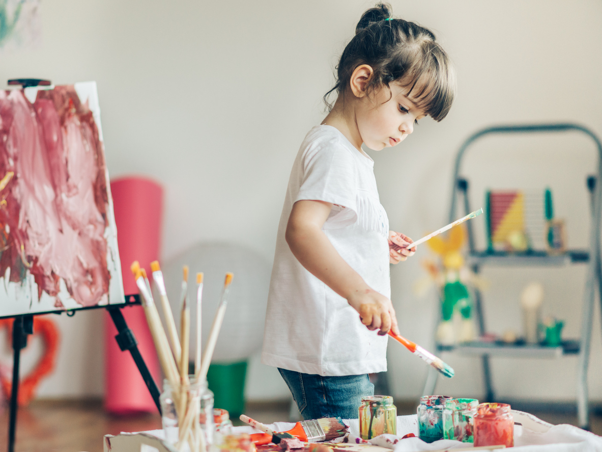 Cut girl painting in at her home.